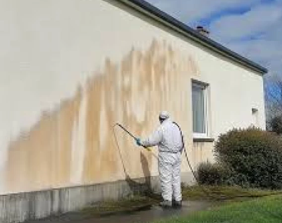 Nettoyage de façade en cours avec pulvérisation produit en Dordogne 24 élimination des traces mur extérieur